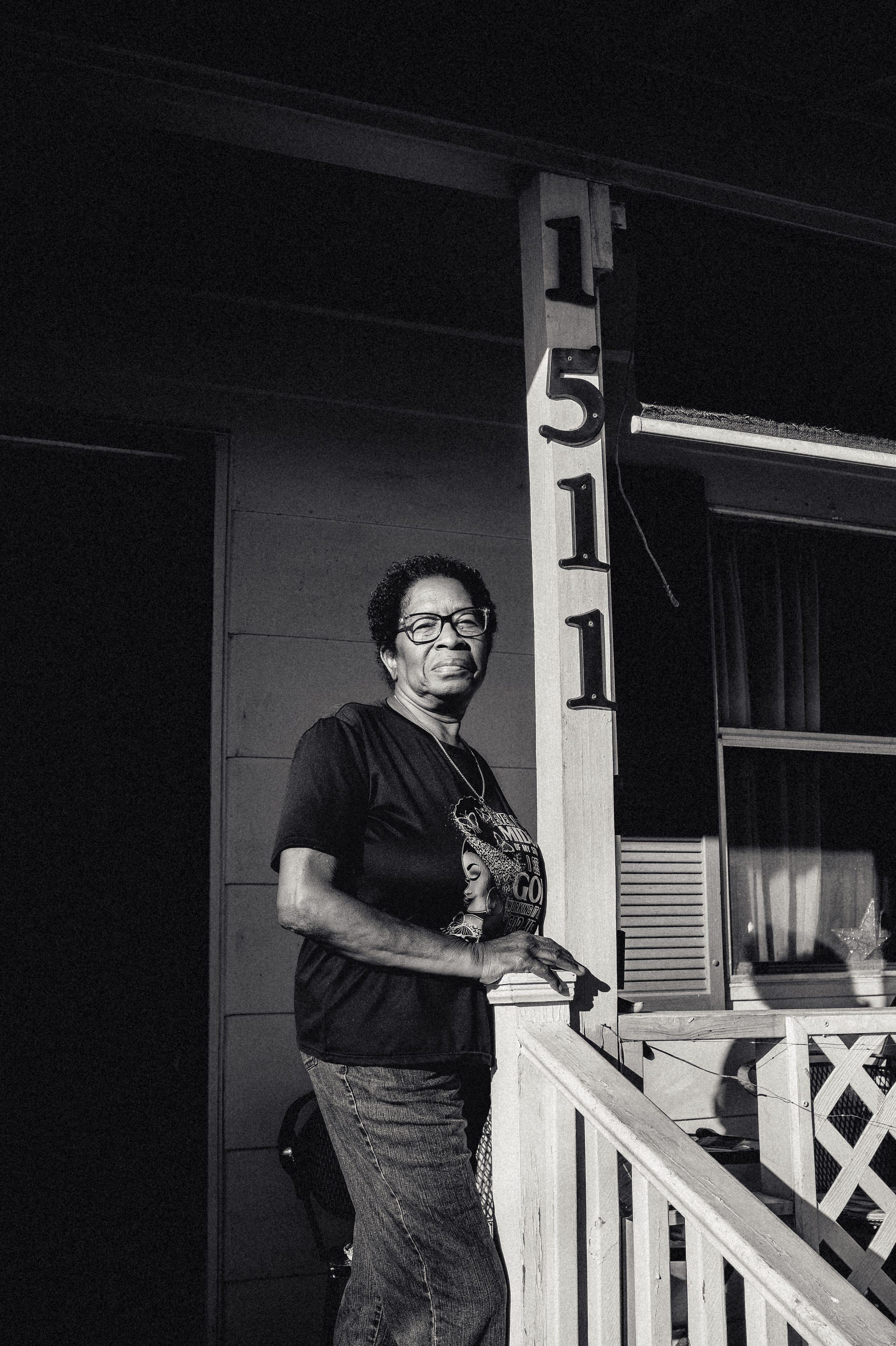 A woman standing on her porch after dark.
